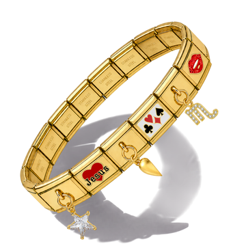 A gold-tone metal stretch bracelet featuring various charms, including a red heart with 'JESUS' in black lettering, a red heart with 'I LOVE YOU' in white, playing card symbols, a rhinestone 'M' charm, a dangling star, and engraved nameplates on each segment, shown on a white background with a soft shadow.